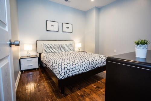 a bedroom with a bed and a desk with two lamps at Lawrenceville Suites in Pittsburgh