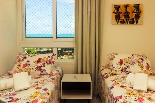 two beds in a small room with a window at Marina Bezerril - 304 Pontamares - Pertinho de tudo,mar e restaurantes in Natal