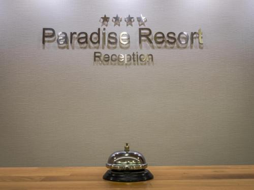 a clock sitting on a table in front of a sign at Paradise Resort in Finikounta