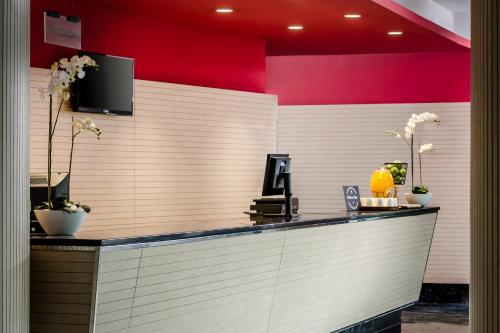 a lobby with a counter with a red wall at Eurostars Reina Felicia in Jaca