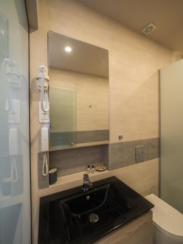 a bathroom with a sink and a mirror at Paradise Resort in Finikounta