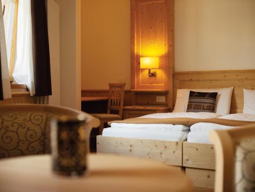 a bedroom with two beds and a table and chairs at Garni Le Maddalene in Coredo