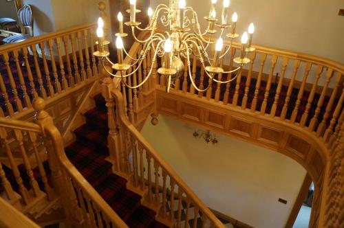 a staircase with a chandelier at Kilcreeny Lodge in Lisburn
