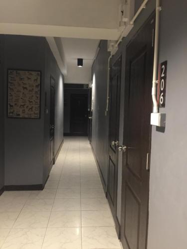a hallway with black walls and a white tile floor at KC guest house in Bangkok