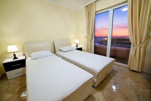 a hotel room with two beds and a window at Apartments Panorama Alaj in Ulcinj