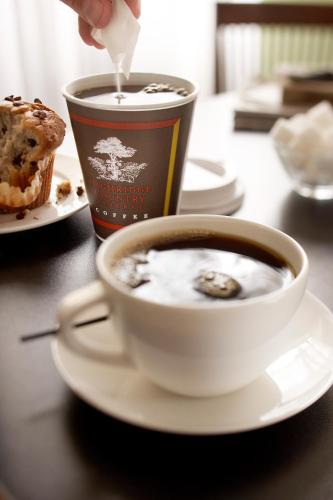 a cup of coffee sitting on a table with a cup of food at Country Inn & Suites by Radisson, Erie, PA in Erie