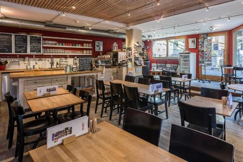 ein Restaurant mit Tischen und Stühlen und eine Bar in der Unterkunft Le Café-Hôtel de L'Aubier in Neuenburg