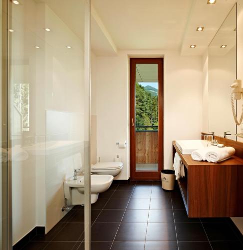 a bathroom with a toilet and a sink and a shower at Naturhotel Die Waldruhe GmbH in Chienes