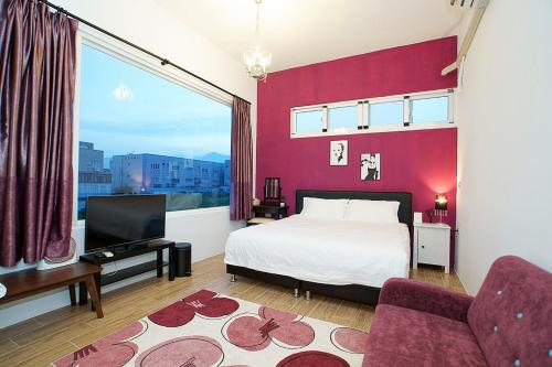 1 dormitorio con cama blanca y pared roja en Time Travel B&B en Taitung