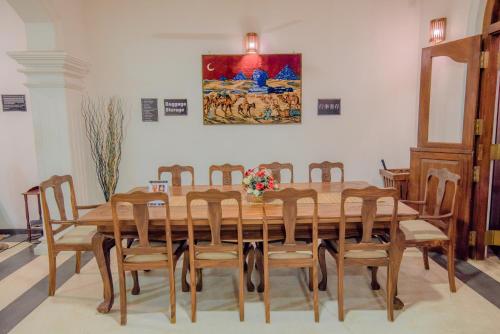 a dining room table with chairs and a painting on the wall at Muhsin Villa - Galle Fort in Galle