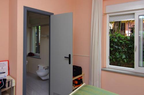 a bathroom with a toilet and a window at Hotel Cristallo in Lerici