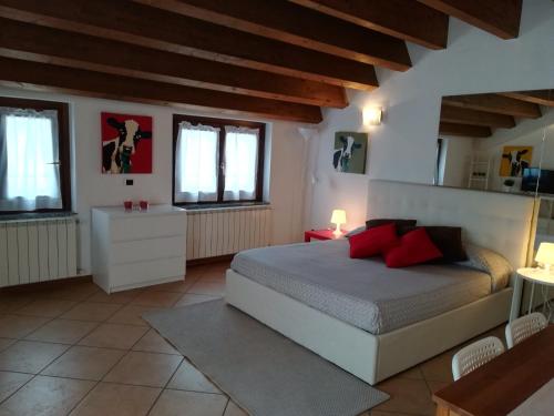 Un dormitorio con una cama grande con almohadas rojas. en Rovelli Room, en Bérgamo