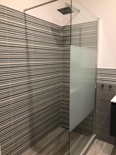 a shower with a glass door in a bathroom at Four Rooms in Bologna