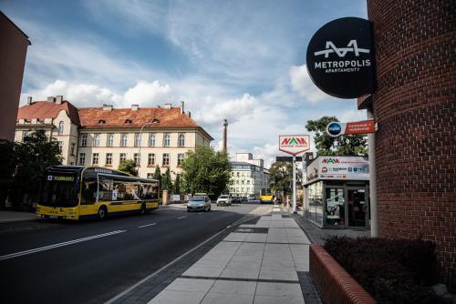 a yellow bus is driving down a city street at Metropolis Apartamenty Centrum in Kalisz