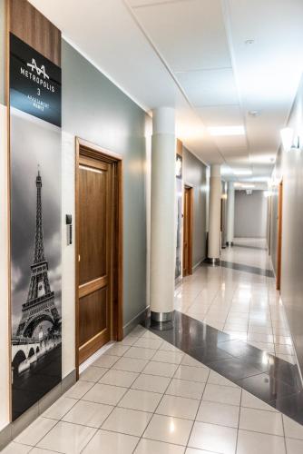 a hallway with a door and a picture of the eiffel tower at Metropolis Apartamenty Centrum in Kalisz