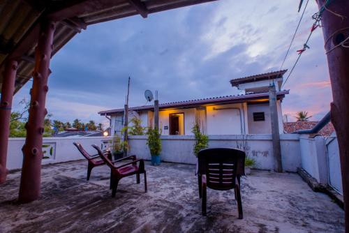 a patio with two chairs and a house at Muhsin Villa - Galle Fort in Galle