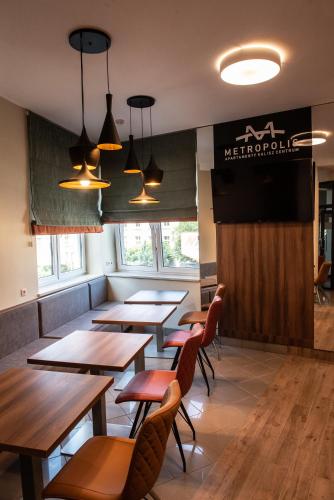 a restaurant with wooden tables and chairs and a screen at Metropolis Apartamenty Centrum in Kalisz