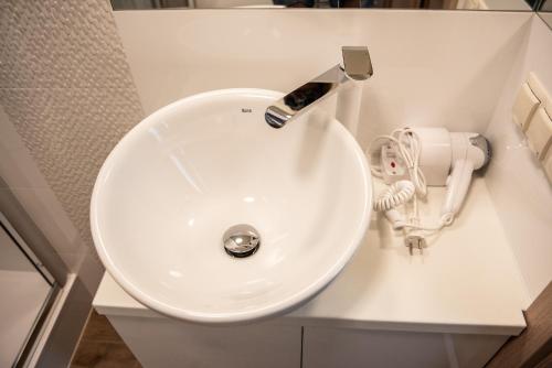 a white sink with a faucet in a bathroom at Metropolis Apartamenty Centrum in Kalisz