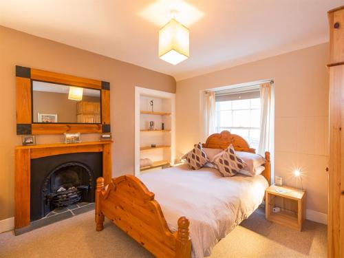 una camera da letto con un letto e un camino di River Cottage a Inverness