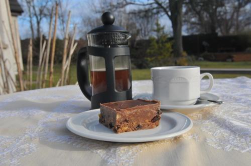 a piece of chocolate cake and a cup of coffee at Home Farm Bed and Breakfast in Muir of Ord
