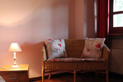 a wicker couch sitting in a room with a lamp at La Collina dei Passeri in Pocapaglia