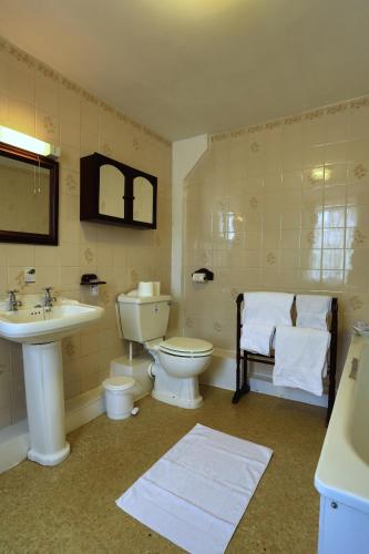 a bathroom with a sink and a toilet and a sink at Best Western The George Hotel, Swaffham in Swaffham