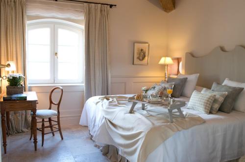 a bedroom with a bed with a table and a window at La Casa de los Tomillares in Candeleda