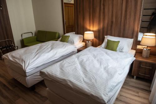 a hotel room with two beds and a chair at Metropolis Apartamenty Centrum in Kalisz