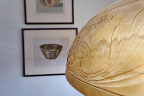 a close up of a wooden bowl in front of framed pictures at Casa Culinaria - The Gourmet Inn in Santa Fe