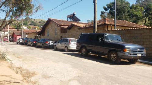 a line of cars parked on the side of a street at Pousada Tia Lilía in Gonçalves