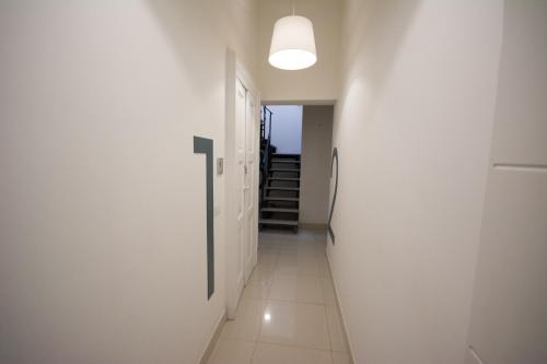 a hallway with white walls and a light fixture at Palazzo di Fazio Suites in San Severo