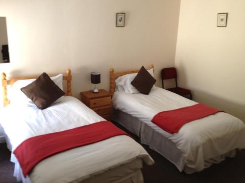 a hotel room with two beds and two nightstands at Drovers Arms Hotel in Carmarthen