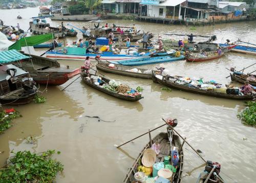 a group of boats in a river with people on them at BOSA Homestay - Mekong Riverside in Can Tho