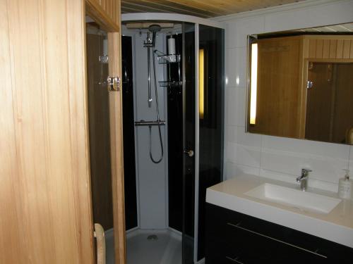 a bathroom with a shower and a sink and a sink at Elvestua in Gibostad