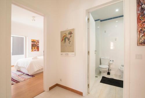 リスボンにあるArt and Design Apartment in Lisbonの白いバスルーム(トイレ付)、ベッド1台が備わります。