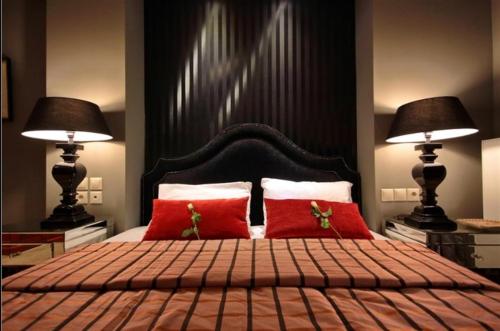 a bedroom with a large bed with red pillows at Nerida Boutique Hotel in Dhimitsana
