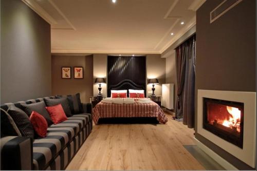 ディミツァナにあるNerida Boutique Hotelのベッドルーム(ベッド1台、ソファ、暖炉付)