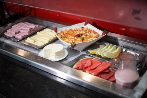 a buffet line with cheese and meats and other food at Assay Plaza Hotel in Hortolândia