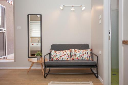 a mirror and a bench in a room at Tslil Suite in Yeroẖam