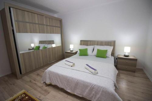 a bedroom with a large bed with green pillows at Apartment Garden in Blagaj