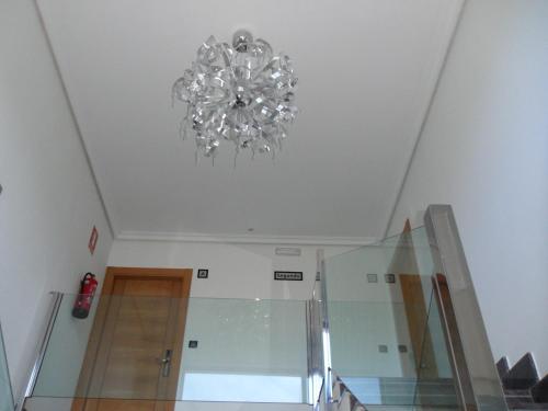 una lámpara de araña colgando del techo de una habitación en Apartamentos Turisticos Estrella del Alemar en Langre