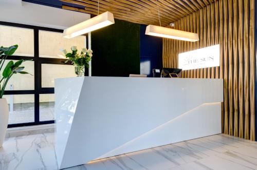 a white reception desk in a room with windows at The Sun by Lubicz in Ustka