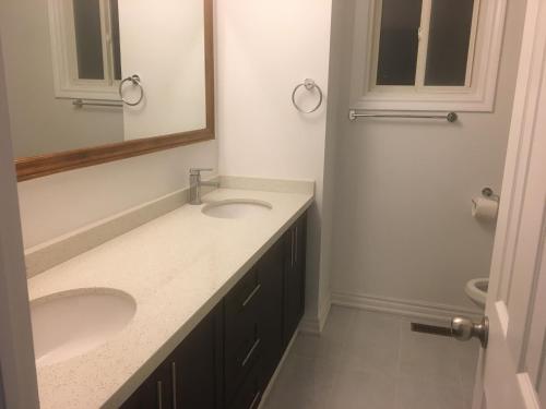 a bathroom with two sinks and a mirror at Home Base in Markham