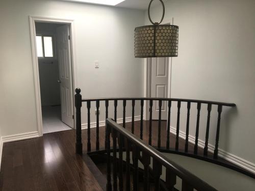 a room with a staircase and a chandelier at Home Base in Markham