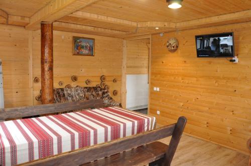 1 dormitorio con 1 cama en una cabaña de madera en Shpin, en Vorokhta