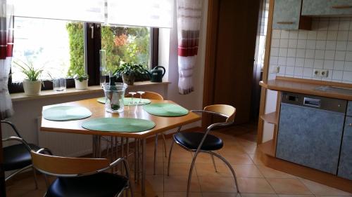kuchnia z drewnianym stołem z krzesłami i oknem w obiekcie Ferienwohnung Saarblick w mieście Ockfen