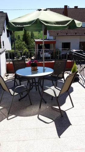 a table and chairs with an umbrella on a patio at Ferienwohnung Saarblick in Ockfen