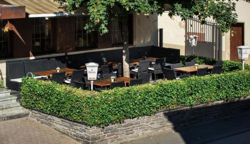 a restaurant with tables and chairs in front of a building at Hotel Weinhaus Weis in Leiwen