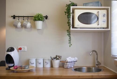 a kitchen counter with a sink and a microwave at Tslil Suite in Yeroẖam