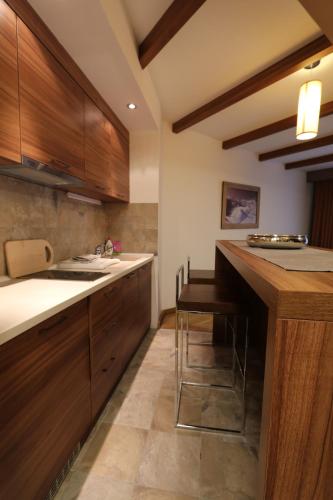 a kitchen with wooden cabinets and a counter top at Lux Private Apartment Vučko in Jahorina